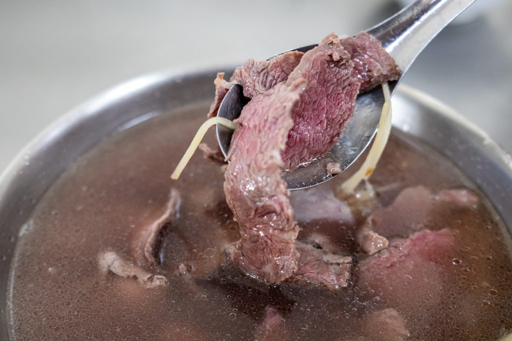 筷子夾起王家牛肉湯的溫體牛肉片,油花分布飽滿