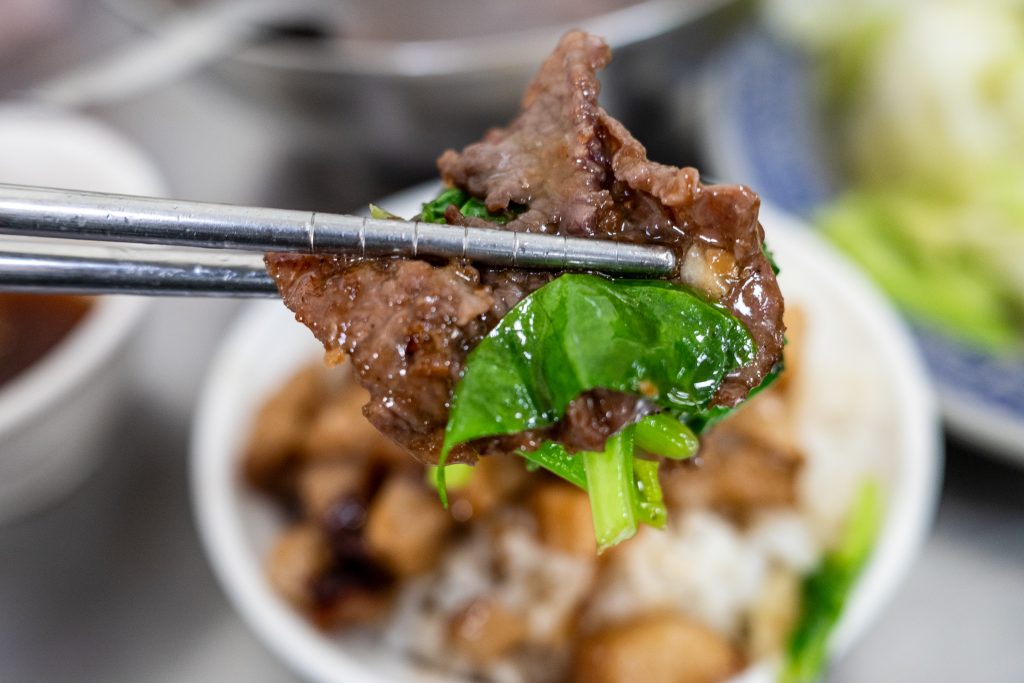 筷子夾起王家牛肉湯的芥藍炒牛肉,醬汁裹附在牛肉與芥藍上