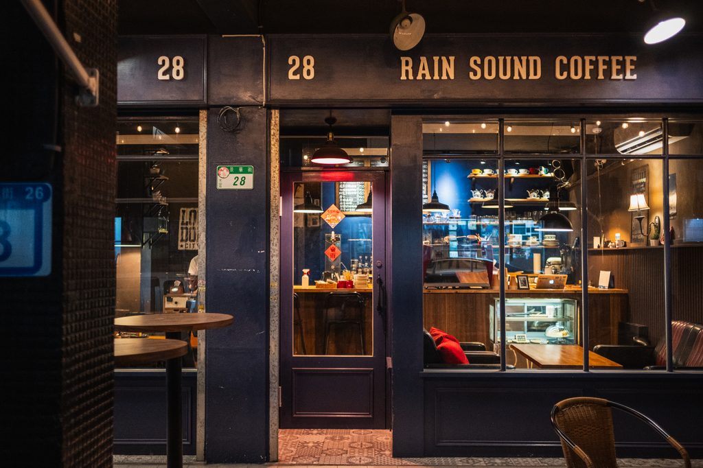 入夜後的雨聲咖啡,深藍色門面與亮起的 RAIN SOUND COFFEE 招牌