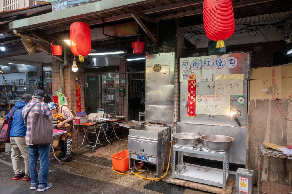 阿角紅燒肉劉美麗位在台北大同太平市場的攤位外觀，紅燈籠下擺著路邊炸爐與兩個大鐵盆