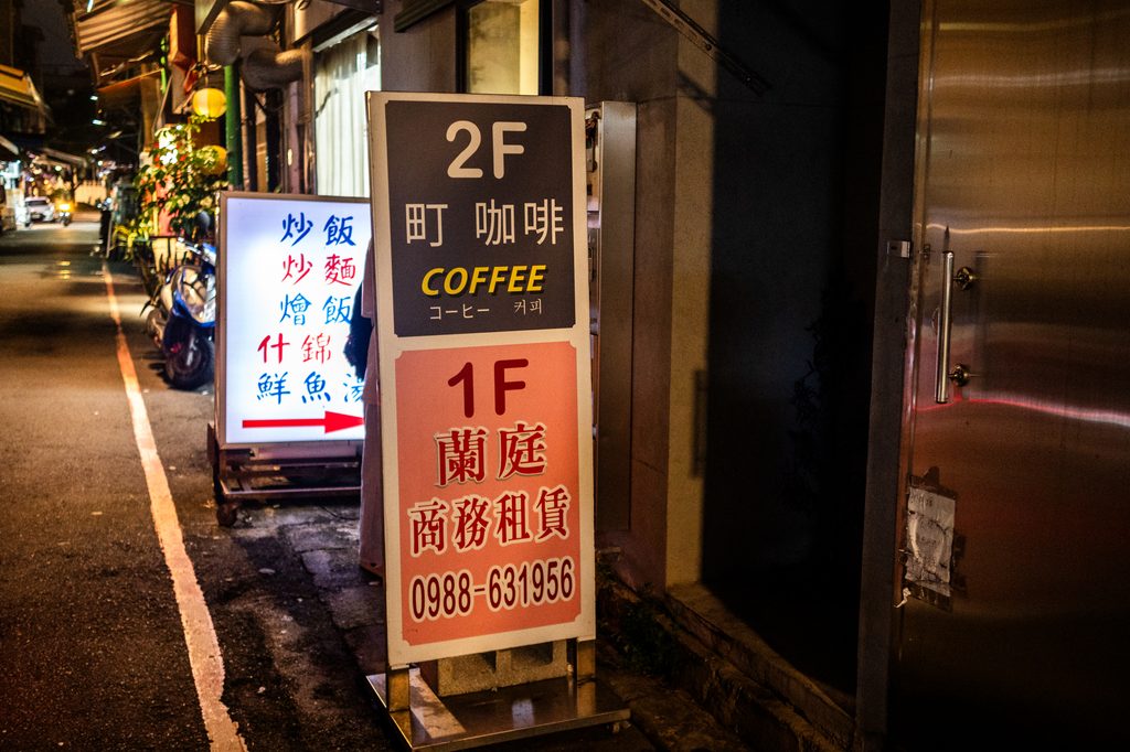 町咖啡門口的立牌，上半寫著 2F 町咖啡 COFFEE，下半是紅字的 1F 蘭庭商務租賃
