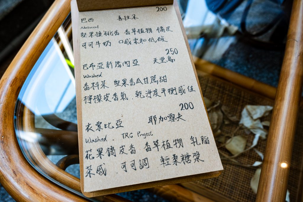 何家人珈琲的手寫單品咖啡菜單,巴西喜拉朵200元、巴布亞新幾內亞天堂鳥250元、衣索比亞耶加雪夫200元,每支都附產區處理法與風味描述