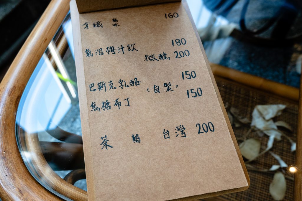 何家人珈琲的手寫飲品與甜點菜單,拿鐵160元、氣泡梅汁飲180元、微醺版200元、巴斯克乳酪150元、焦糖布丁150元、台灣茶200元