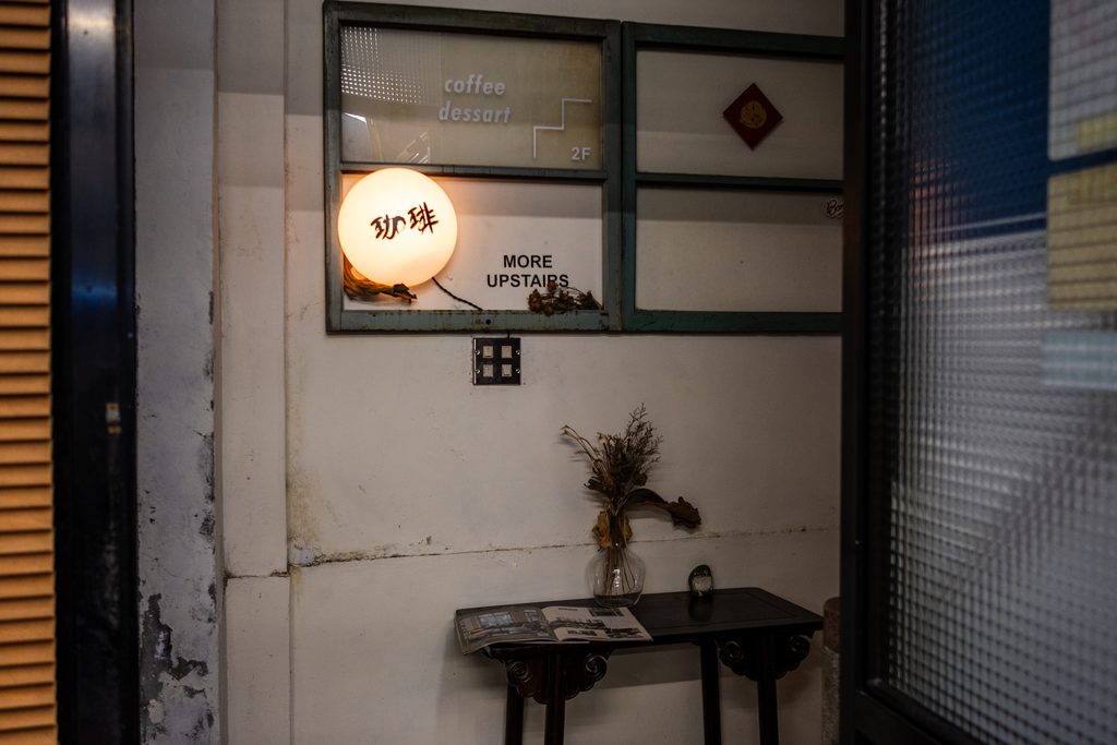 二樓入口的毛玻璃窗寫著 coffee dessert,旁邊掛著發光的珈琲圓燈與 MORE UPSTAIRS 指示